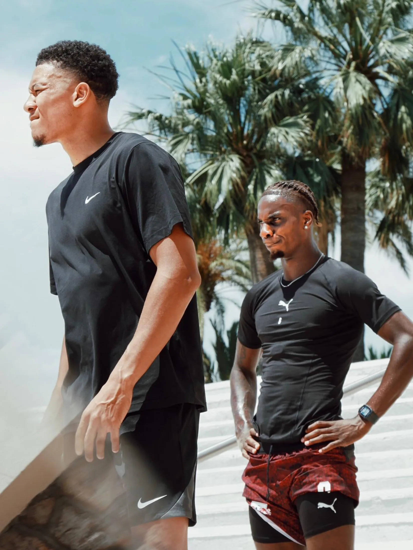 Two players on a palm-lined road, preparing during the off-season
